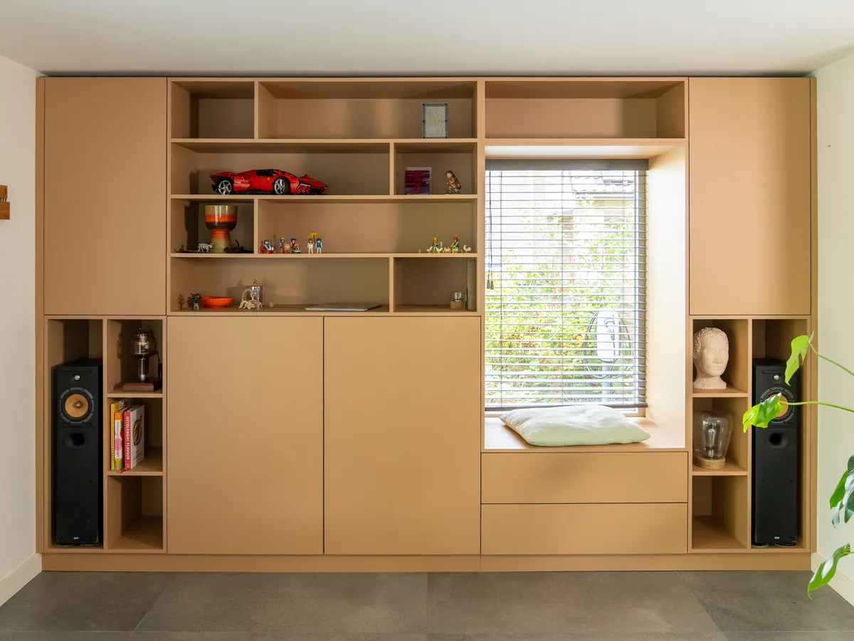 Een boekenkast in lichte eikenkleur rond een raam