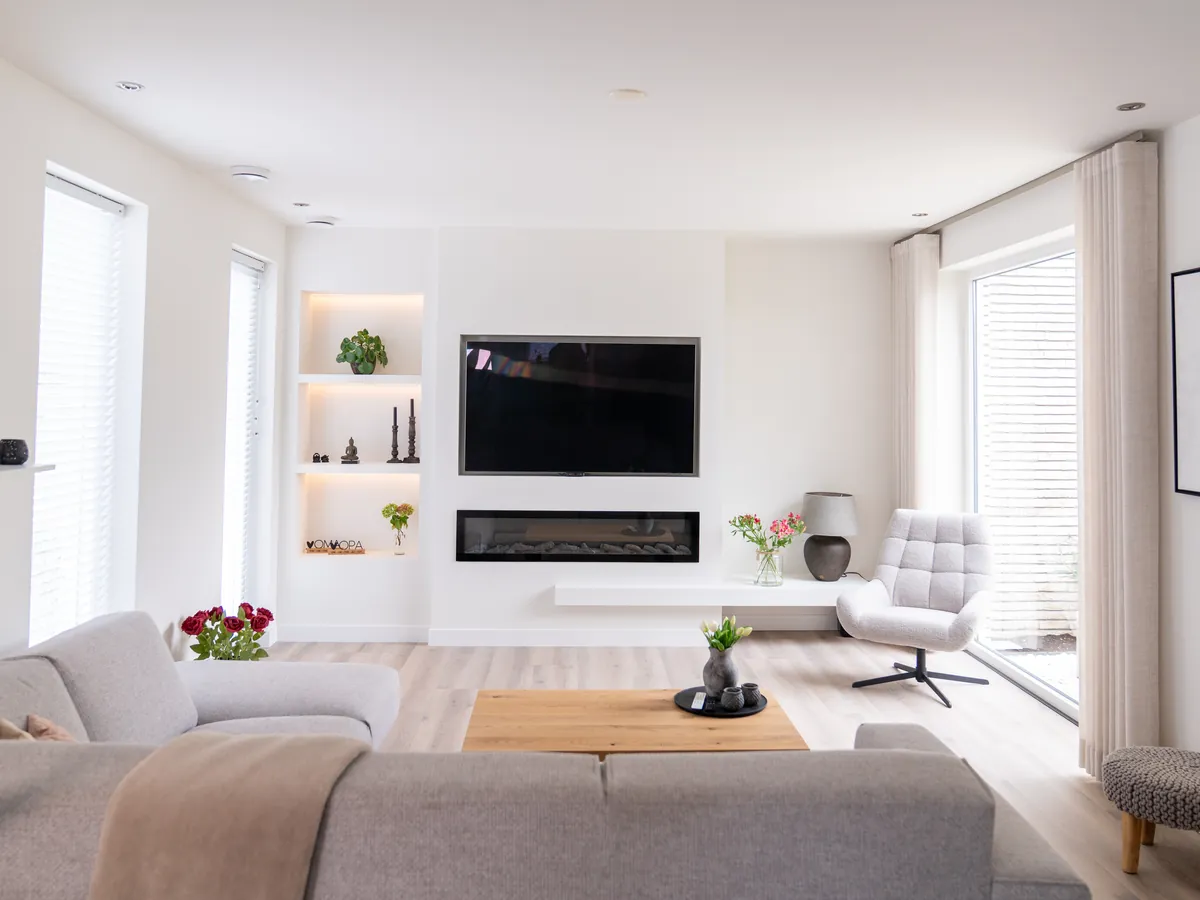 Een woonkamer met een witte tv-wand van Maakfabriek